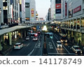 黃昏前，車站前車輛和行人來來往往。城市燈光逐漸照亮了都市景觀。 141178749