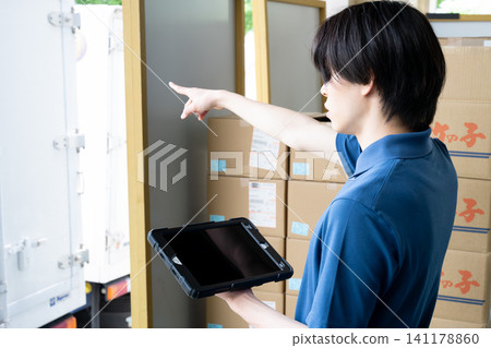 A man's hands using a tablet in a warehouse A man's hands using a tablet in a warehouse 141178860