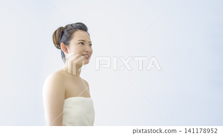 A beauty image of a young woman smiling in a bath towel. A beauty image of a young woman smiling in a bath towel. 141178952
