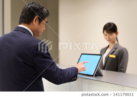 A man checking into a hotel A man checking into a hotel 141179831