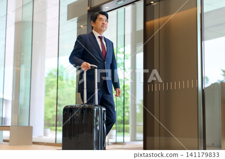 Asian businessman walking with a suitcase Asian businessman walking with a suitcase 141179833