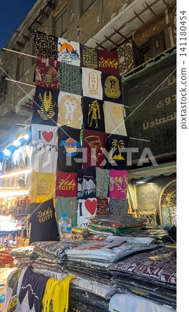 Samples of Egyptian T-shirts in various designs displayed at a street-side souvenir shop Samples of Egyptian T-shirts in various designs displayed at a street-side souvenir shop 141180454