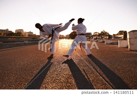 People, karate and fitness with personal trainer in city street for self defense, fighting technique or style. Man and woman fighter or athlete in training, martial arts or kick boxing in urban town 141180511