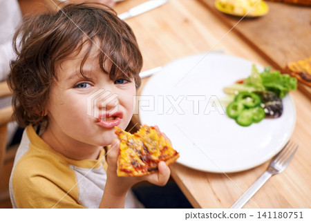 Boy, child and pizza in portrait at dinner table for eating, food and relax on holiday in family house. Kid, happy and playful in dining room for lunch with nutrition, diet and home for funny face Boy, child and pizza in portrait at dinner table for eating, food and relax on holiday in family house. Kid, happy and playful in dining room for lunch with nutrition, diet and home for funny face 141180751