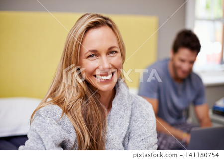 Woman, smile and portrait with partner, bed and laptop for morning internet routine. Happy, couple and home with bedroom, pyjamas and robe together in house with technology for relationship and love 141180754