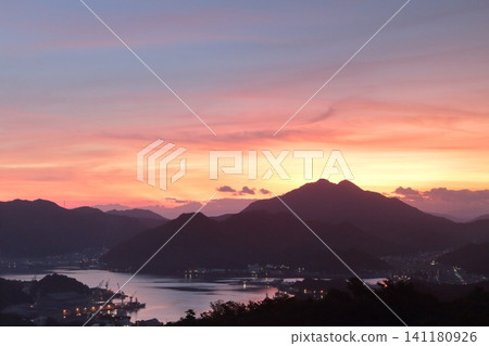 夕陽西下,大海和城市沐浴在金色的餘暉中。 夕陽西下,大海和城市沐浴在金色的餘暉中。 141180926