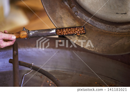 Coffee beans, machine and hands in factory for roast, grinding or production for flavor, export or quality assurance. Person, metal container and caffeine manufacturing with organic stock for ecology Coffee beans, machine and hands in factory for roast, grinding or production for flavor, export or quality assurance. Person, metal container and caffeine manufacturing with organic stock for ecology 141181021