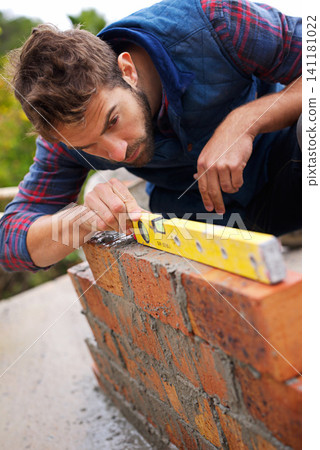 Man, spirit level and construction for bricklayer, working employee in industrial industry and contractor career. Serious, male person and balance tool or handyman for renovation on building project Man, spirit level and construction for bricklayer, working employee in industrial industry and contractor career. Serious, male person and balance tool or handyman for renovation on building project 141181022