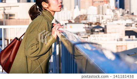 一位女子站在陽台上眺望遠方。 一位女子站在陽台上眺望遠方。 141181438