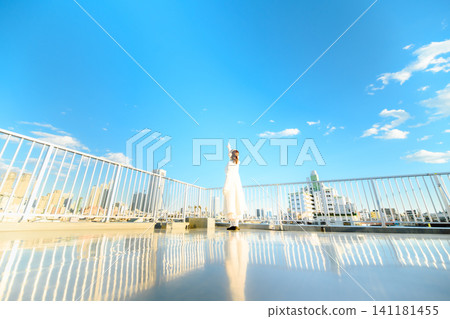 A woman with her arms outstretched on a rooftop A woman with her arms outstretched on a rooftop 141181455