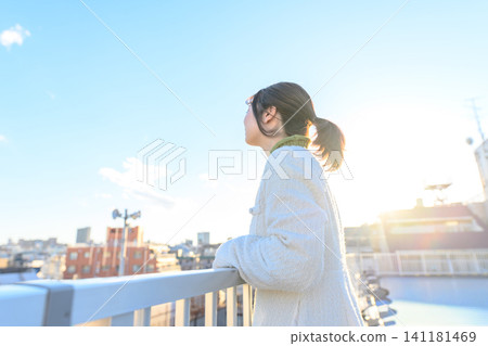 A woman looking up at the blue sky A woman looking up at the blue sky 141181469
