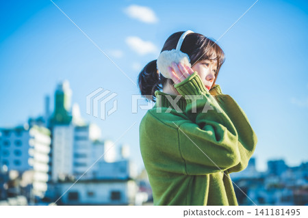 一位女士在寒冷的空氣中戴著耳罩 141181495