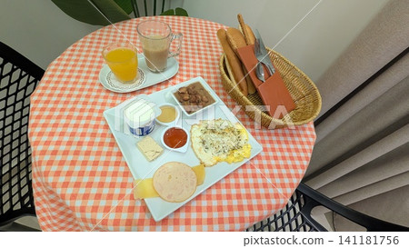 Breakfast set with egg, cheese, ham, yogurt, bread, beans, halva, juice, and coffee Breakfast set with egg, cheese, ham, yogurt, bread, beans, halva, juice, and coffee 141181756