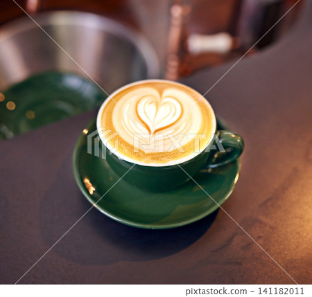 Coffee, cup and latte with art for creativity, closeup of cappuccino or caffeine drink on counter with pattern. Warm beverage, foam and milk with heart design, hospitality and table service at cafe Coffee, cup and latte with art for creativity, closeup of cappuccino or caffeine drink on counter with pattern. Warm beverage, foam and milk with heart design, hospitality and table service at cafe 141182011