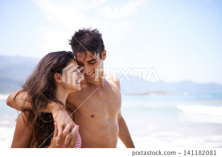 Beach, love and couple with vacation, summer and weekend break for honeymoon and adventure. Travel, seaside and embrace with man and woman with holiday and love with anniversary, happiness and ocean 141182081