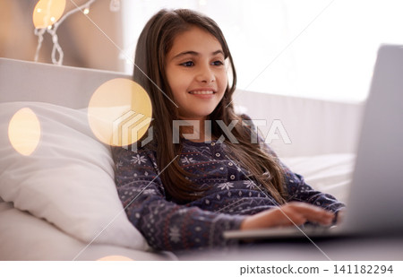 Movies, night or kid with laptop for streaming, playing games and watching videos on a film website. Smile, house or happy female child with technology to download online or social media app to relax Movies, night or kid with laptop for streaming, playing games and watching videos on a film website. Smile, house or happy female child with technology to download online or social media app to relax 141182294