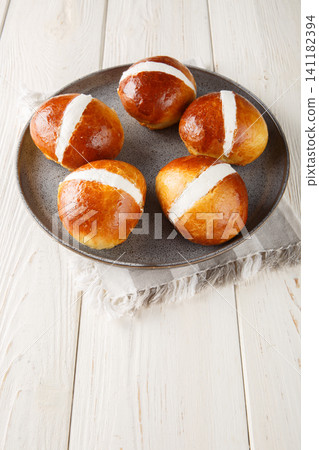 Homemade MARITOZZO is Italian bread stuffed with whipped cream close-up in a plate. Vertical Homemade MARITOZZO is Italian bread stuffed with whipped cream close-up in a plate. Vertical 141182394