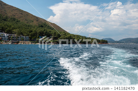 Beautiful sea wave trace from boat with mountain coast Beautiful sea wave trace from boat with mountain coast 141182470