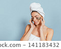 Calm, happy woman relaxing with eye patches on 141183432