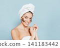 Smiling woman applying facial masks 141183442