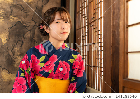一位身穿浴衣的女子在日式房間消磨時光。 一位身穿浴衣的女子在日式房間消磨時光。 141183540
