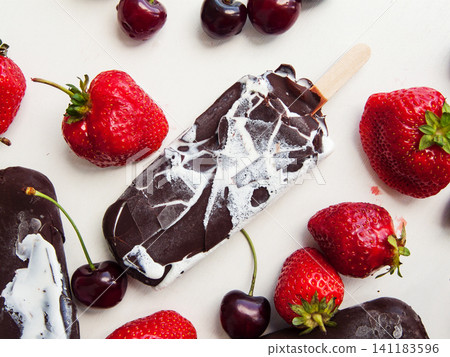 Sweet chocolate vanilla ice cream with red ripe strawberries and cherries, summer refreshing dessert Sweet chocolate vanilla ice cream with red ripe strawberries and cherries, summer refreshing dessert 141183596