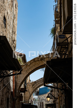 A narrow street among stone houses in old Jerusalem, Israel. 141183816