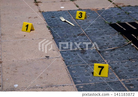 Three yellow crime scene markers on paving slabs Three yellow crime scene markers on paving slabs 141183872