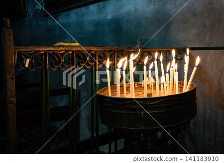 Burning church candles in an ancient temple in the darkness Burning church candles in an ancient temple in the darkness 141183910