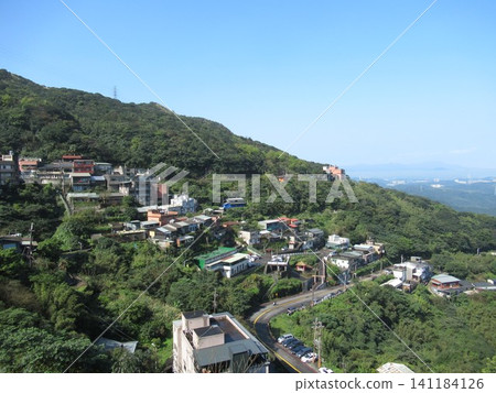 九份的景色,房子沿著綠色的山坡排列。 九份的景色,房子沿著綠色的山坡排列。 141184126