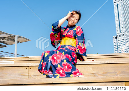 A woman in a yukata blends into the summer scenery. A woman in a yukata blends into the summer scenery. 141184550