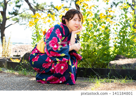 海灘上穿著浴衣的女子 海灘上穿著浴衣的女子 141184801