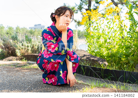 海灘上穿著浴衣的女子 141184802