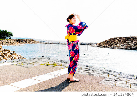 A woman in a yukata on the beach A woman in a yukata on the beach 141184804