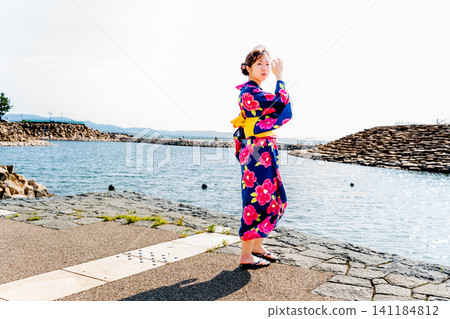 A woman in a yukata on the beach A woman in a yukata on the beach 141184812
