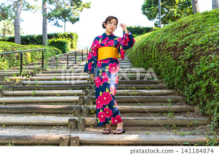 A woman in a yukata blends into the summer scenery. A woman in a yukata blends into the summer scenery. 141184874
