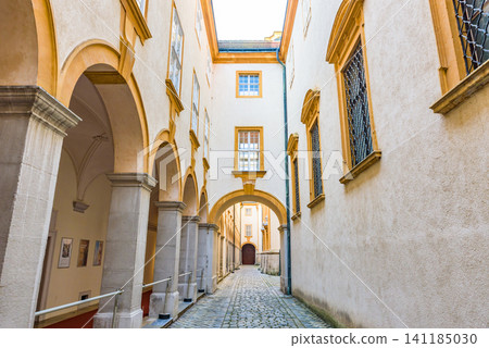 A cobblestone alley nestled between the yellow buildings of Melk Abbey, a UNESCO World Heritage Site and part of the Wachau Valley Cultural Landscape. A cobblestone alley nestled between the yellow buildings of Melk Abbey, a UNESCO World Heritage Site and part of the Wachau Valley Cultural Landscape. 141185030