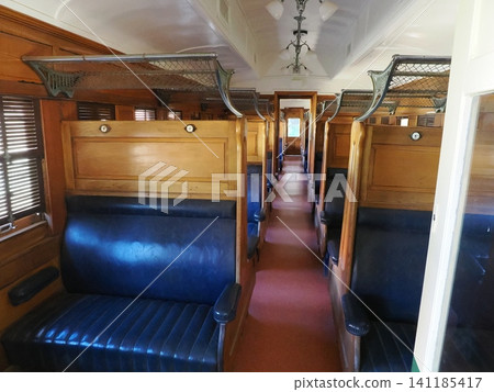 Inside a passenger car at the Sulfide Street Railroad History Museum—a classic seating area with blue bench seats and wooden interior. Inside a passenger car at the Sulfide Street Railroad History Museum—a classic seating area with blue bench seats and wooden interior. 141185417