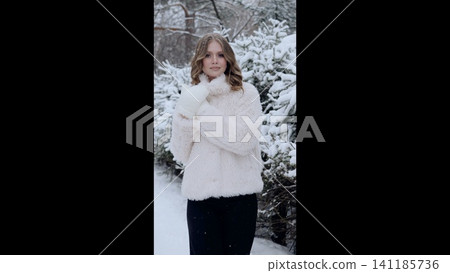Young woman wearing elegant winter outfit standing among snow covered trees, embodying serene woodland winter landscape with graceful presence and soft, magical ambiance Young woman wearing elegant winter outfit standing among snow covered trees, embodying serene woodland winter landscape with graceful presence and soft, magical ambiance 141185736