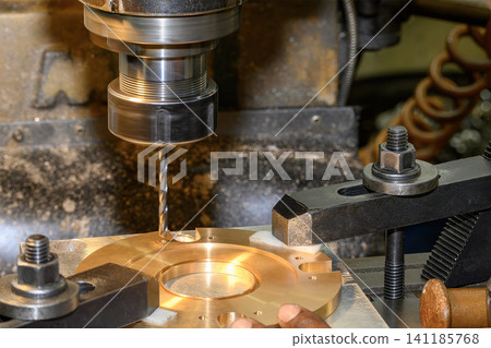High-precision hole making process on a brass material part using a drill tool on a milling machine. High-precision hole making process on a brass material part using a drill tool on a milling machine. 141185768