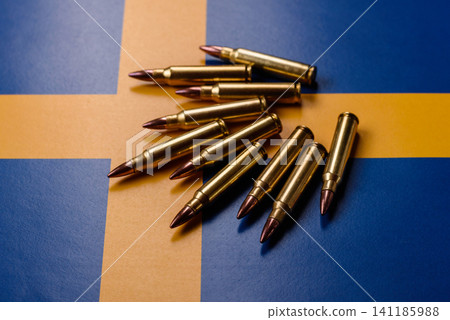 Assault rifle cartridges on the Sweden flag, serving as a conceptual backdrop Assault rifle cartridges on the Sweden flag, serving as a conceptual backdrop 141185988