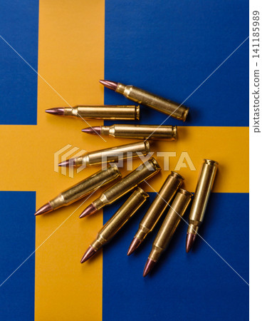 Assault rifle cartridges on the Sweden flag, serving as a conceptual backdrop Assault rifle cartridges on the Sweden flag, serving as a conceptual backdrop 141185989