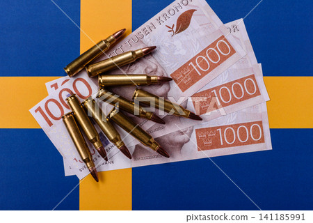 Assault rifle cartridges on the Sweden flag, serving as a conceptual backdrop Assault rifle cartridges on the Sweden flag, serving as a conceptual backdrop 141185991