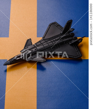 A fighter jet against the Swedish flag as a conceptual background representing defense A fighter jet against the Swedish flag as a conceptual background representing defense 141186000