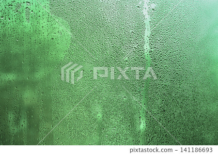 Glass with condensation creates green abstract background Glass with condensation creates green abstract background 141186693