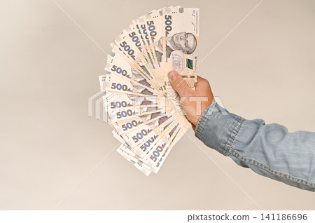 Hand holding a fan of Ukrainian 500 hryvnia banknotes, Hand holding a fan of Ukrainian 500 hryvnia banknotes, 141186696