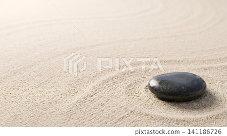 A black stone on a sandy beach A black stone on a sandy beach 141186726