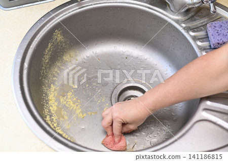 hand using sponge to wash sink interior, hand wiping stainless steel basin with moisture and stains, hand using sponge to wash sink interior, hand wiping stainless steel basin with moisture and stains, 141186815