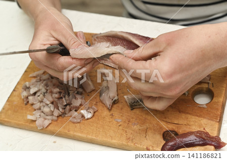 Chef hands cleaning fresh herring fillet for meal. Chef hands cleaning fresh herring fillet for meal. 141186821