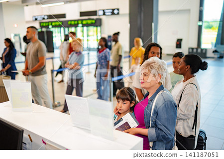 Passengers standing in line at airport check-in counter Passengers standing in line at airport check-in counter 141187051